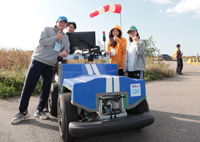 Four students are pictured standing around an autonomous electric vehicle. They used Simcenter Amesim to enhance their design.