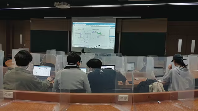 Students use Simcenter Amesim in class at the Chungbuk National University. Four students sit at a table facing a projected screen.