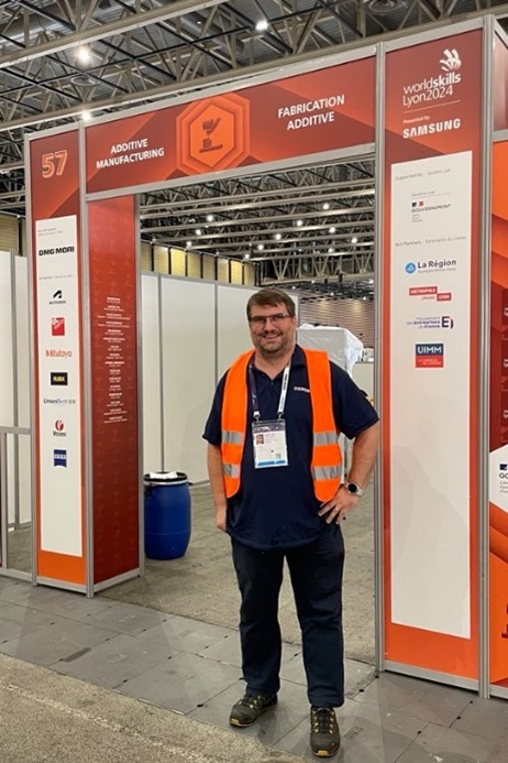 Jonathan Frechard stands in front of a WorldSkills event display.