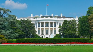 The White House and grounds against a clear blue sky.