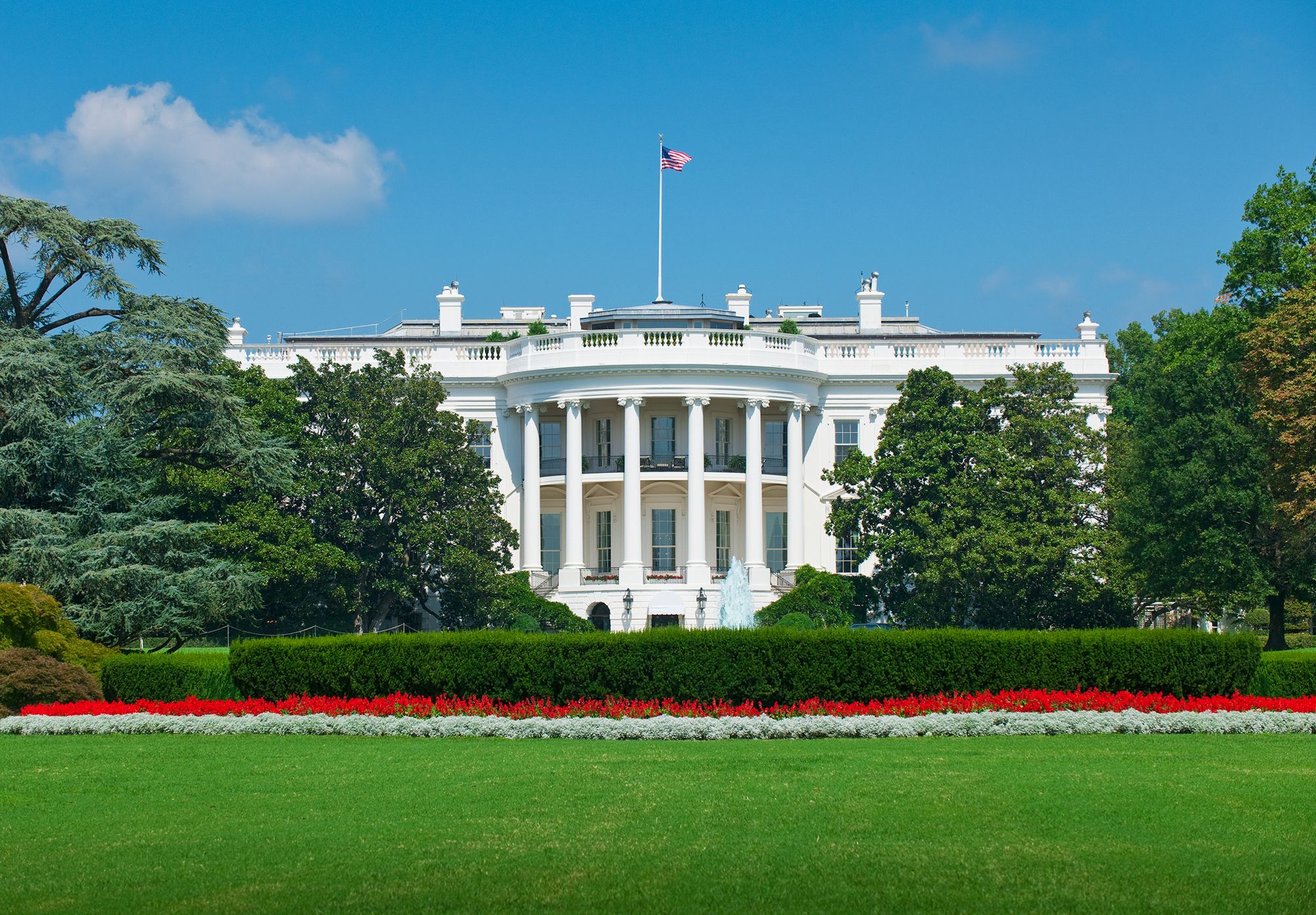 The White House and grounds against a clear blue sky.