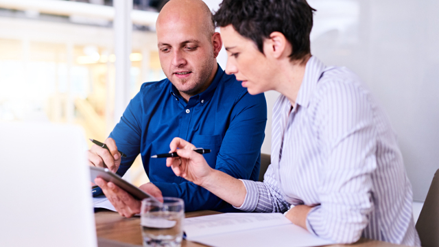 Two engineers reviewing sales configuration on a tablet