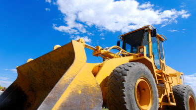 Close-up of a front end loader. large yellow bulldozer from the side