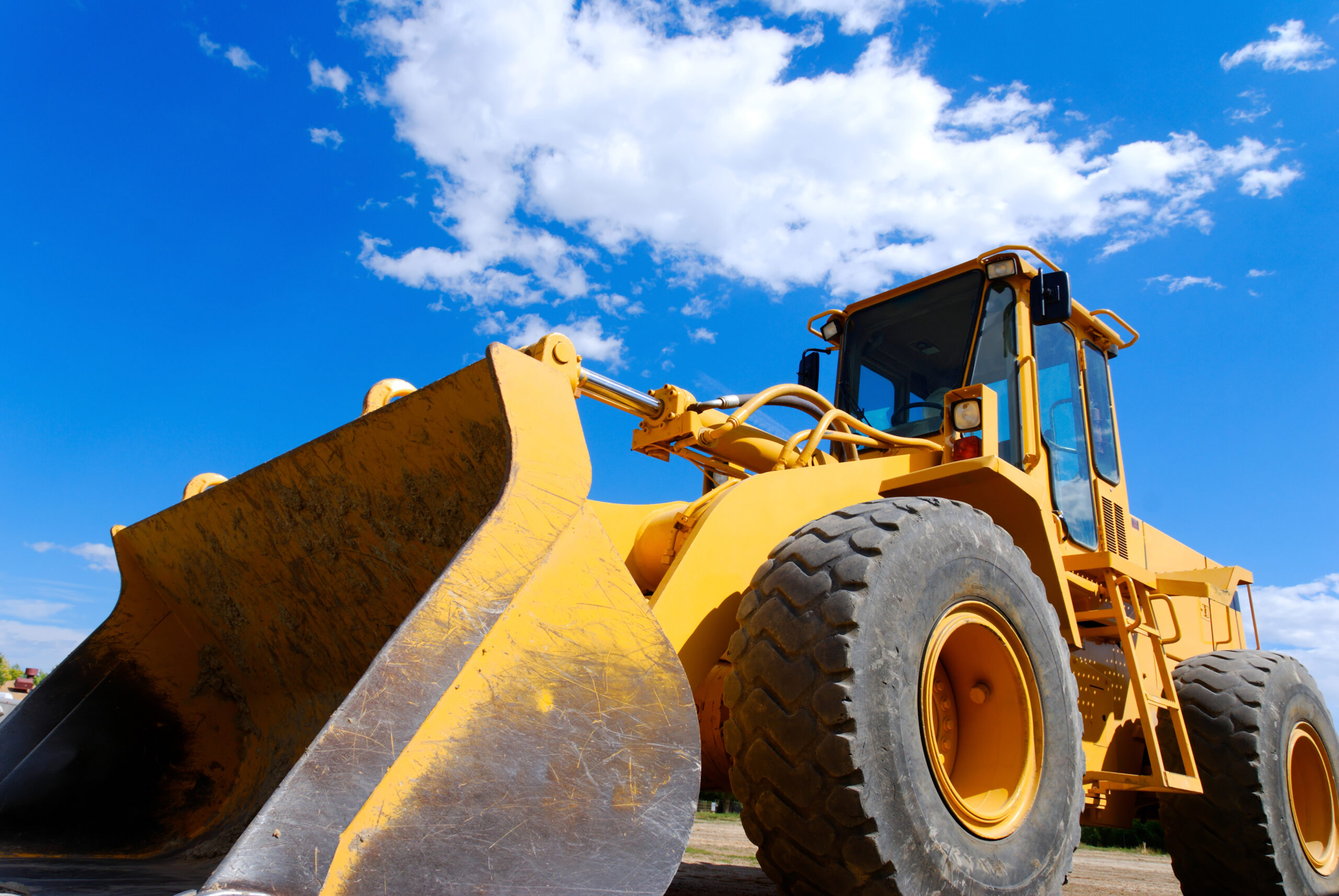 Close-up of a front end loader. large yellow bulldozer from the side