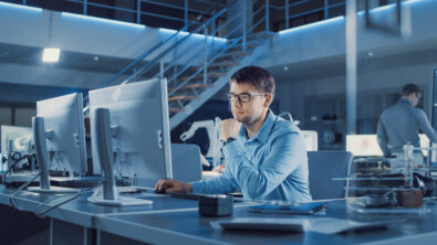 man looking at computer to leverage the enterprise BOM capabilities of the digital thread backbone of Teamcenter