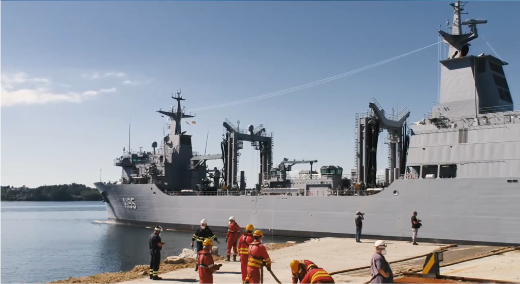 Model-based systems engineering example showing Navantia military ship with workers at the dock.