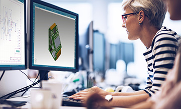 Woman working at computer using CAD software to develop compliant products. Support product compliance management message.