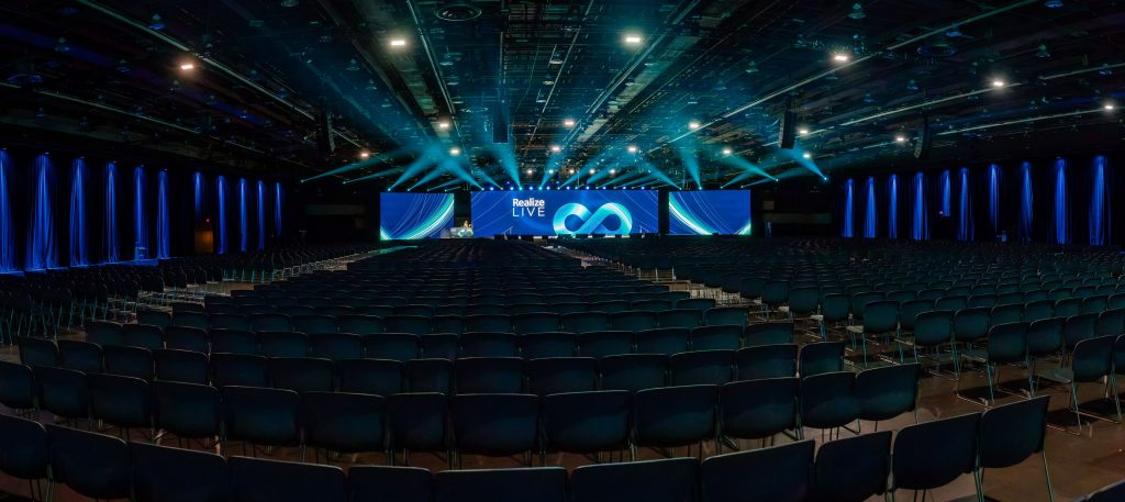 Large room with Realize LIVE on front stage