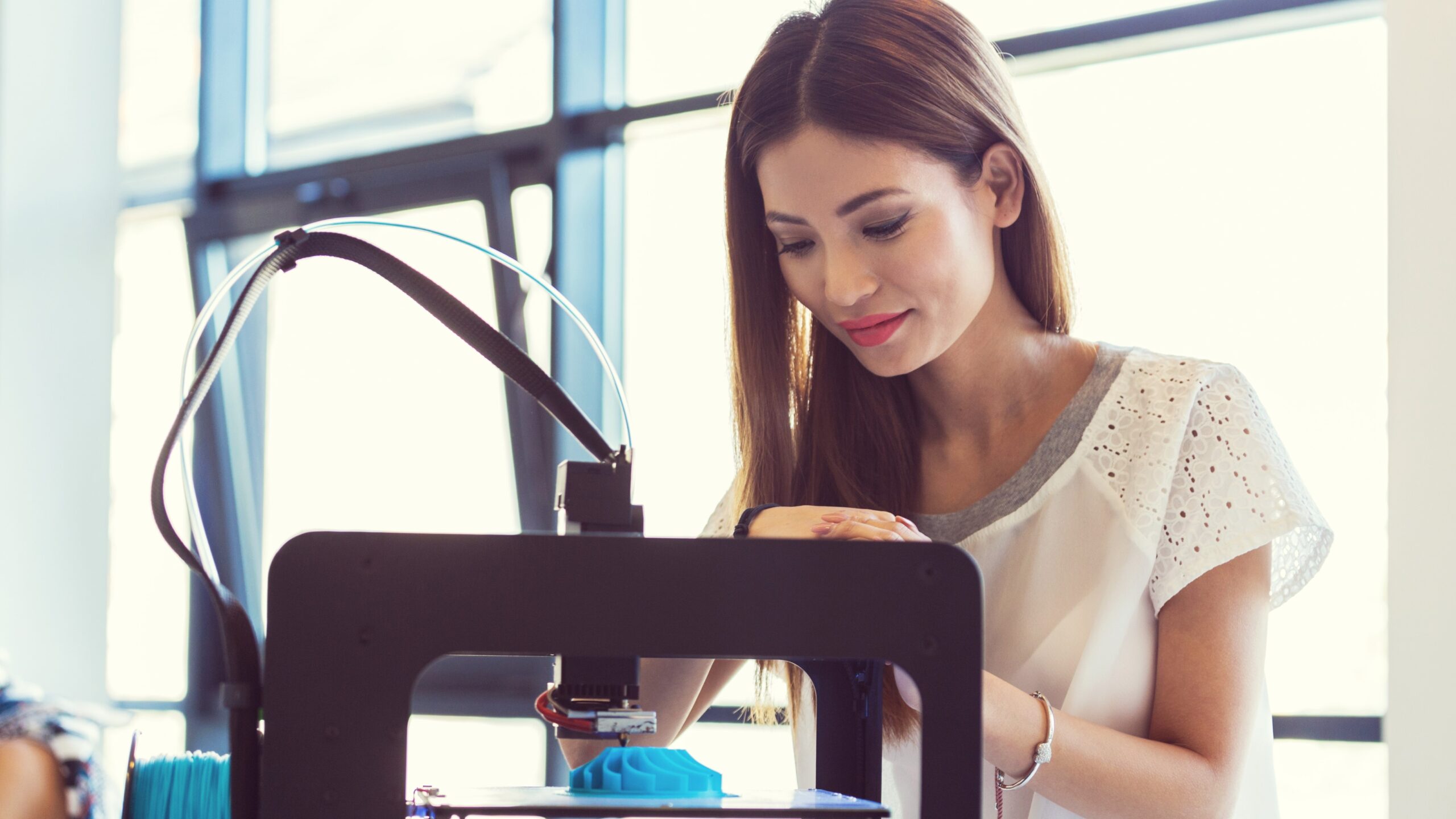 Woman watching polymer 3D printer