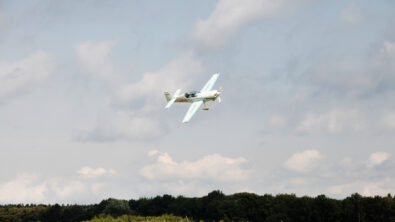 An electric airplane flies through the sky.
