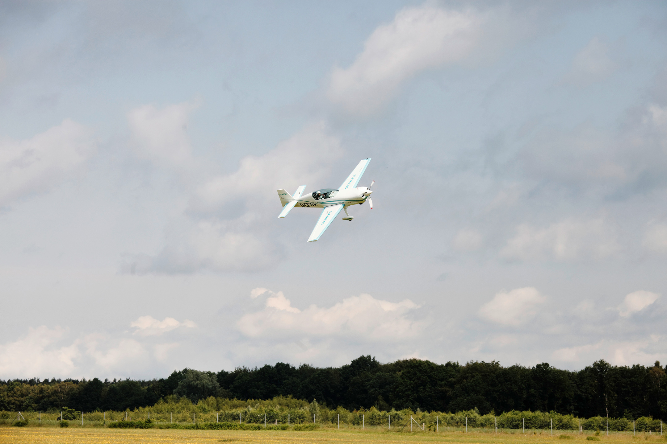 An electric airplane flies through the sky.