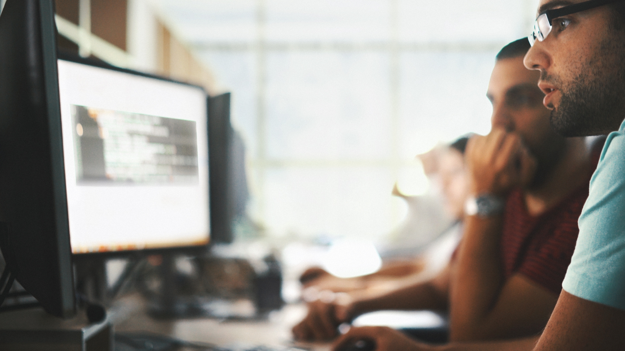 Two software developers looking at a computer.