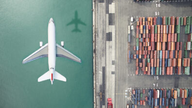 An airplane flying over a container port.