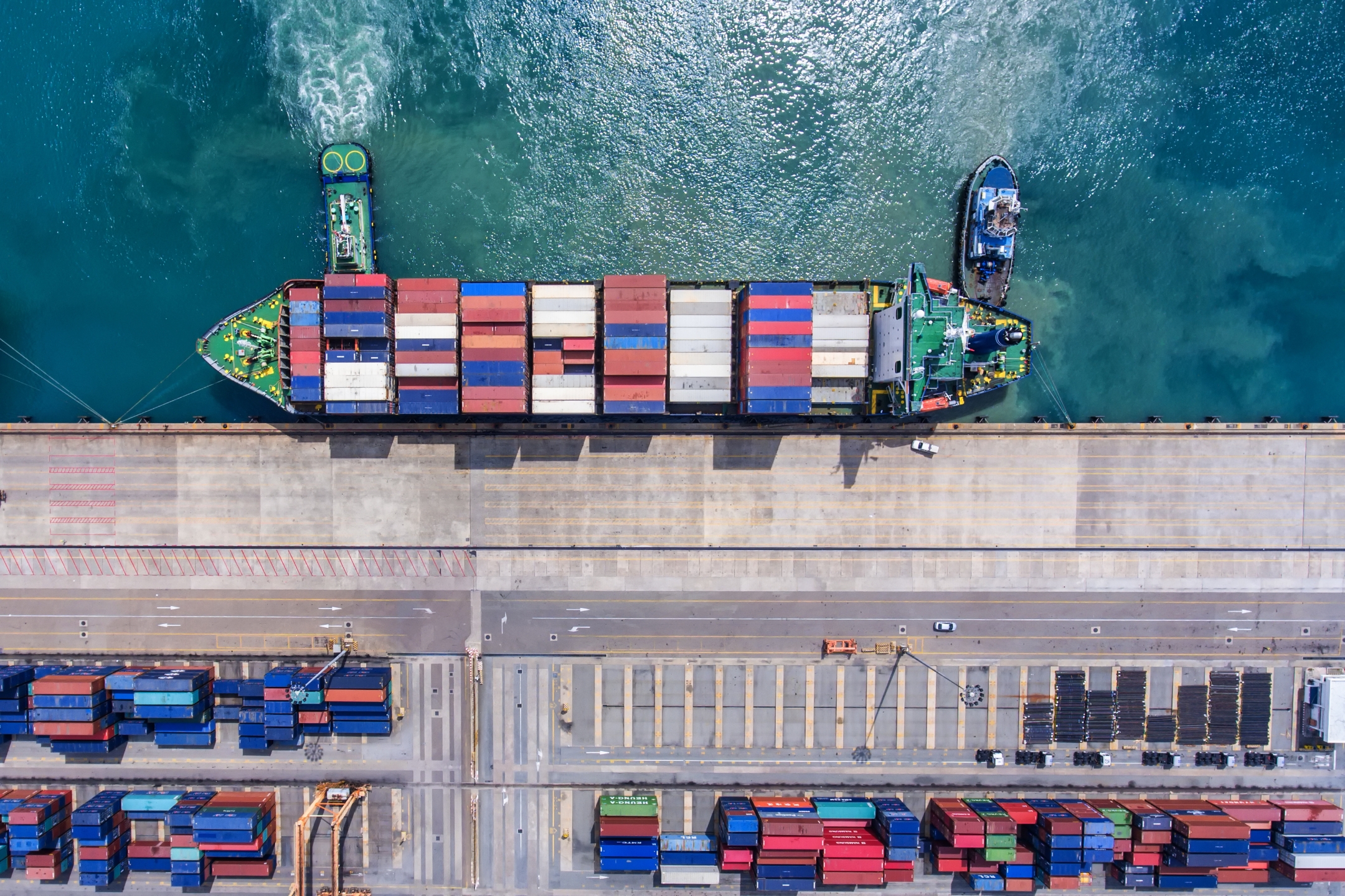 Aerial view of a container ship docked alongside a harbor.