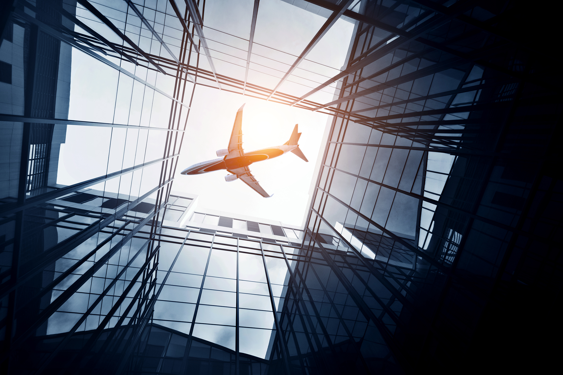 Airplane flying over skyscrapers in a city.