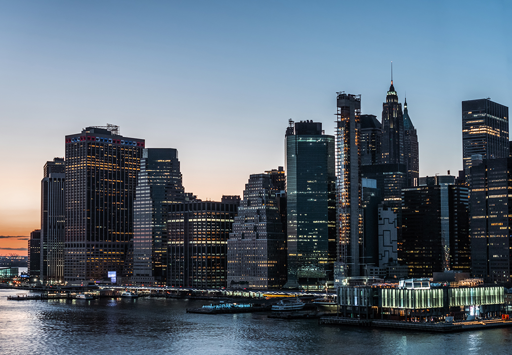 The New York City skyline with a sunset behind it.