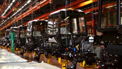 A factory conveyor line moving tractor carriages.