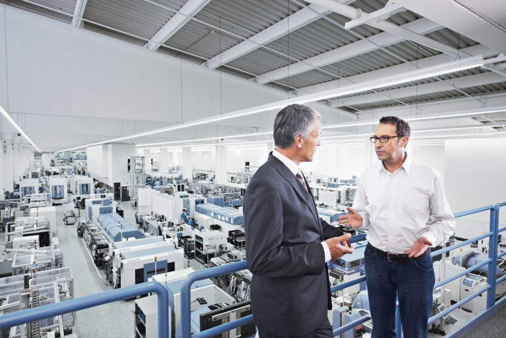 Two people having a conversation over a shop floor.