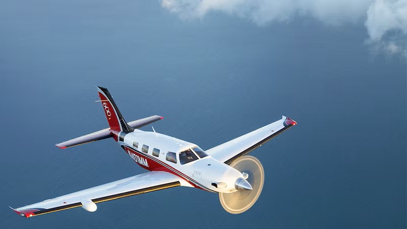 A Piper Aircraft plane flying in a clear blue sky