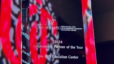 A glass "Employment Partner of the Year" award addressed to Siemens in front of a University of Cincinnati "UC" logo.