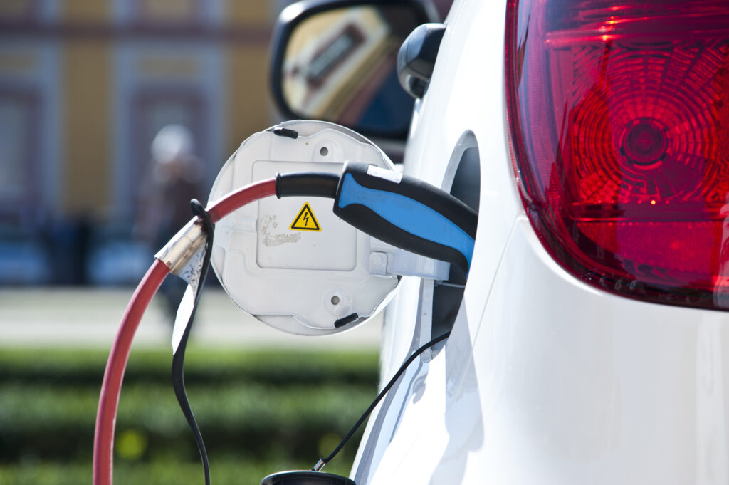 A white electric vehicle being charged