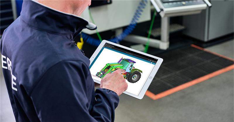 A person on a tablet with the NX X Essentials application open showing a design of a tractor