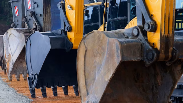 Close-up of three excavator buckets lined up