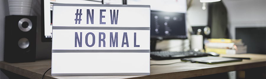 Light signs with text hashtag #NEW NORMAL on the working desk. Work from home. New normal concept. Social distancing.
