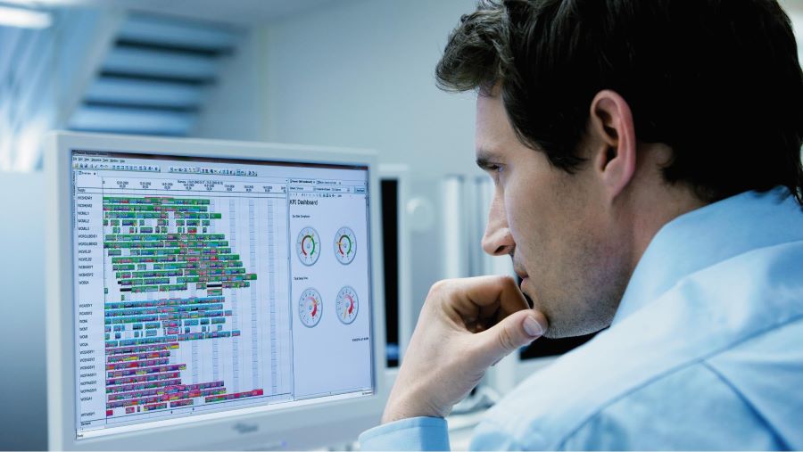 Engineer looking at production scheduling software on computer