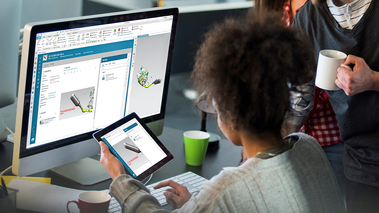 woman looking at tablet and monitor of teamcenter