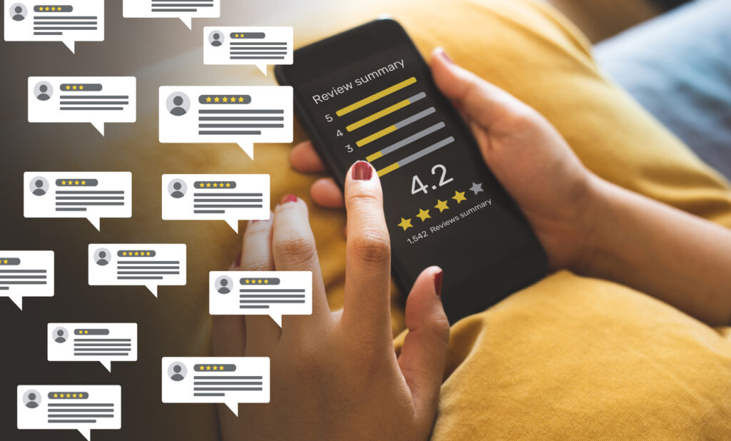 A person's hands hold a cell phone with a business review and ratings summary on the screen.