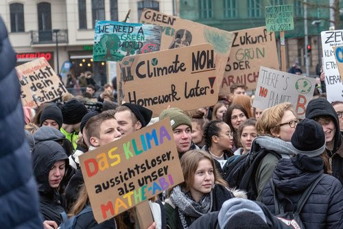Photo of young adults and teenagers protesting for an environmentally-friendly cause.