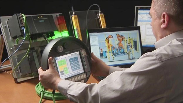 Products are built in digital twins of factories using virtual commissioning technology, as seen in this image of a man in front of a computer.
