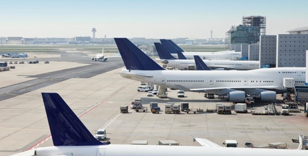 Three airplanes ready for boarding at airport. 