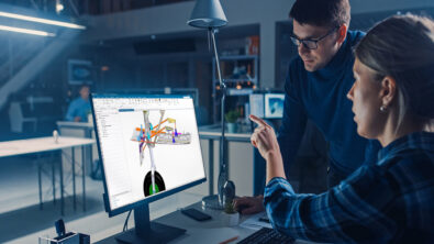 Two engineers look at a landing gear design on a computer screen