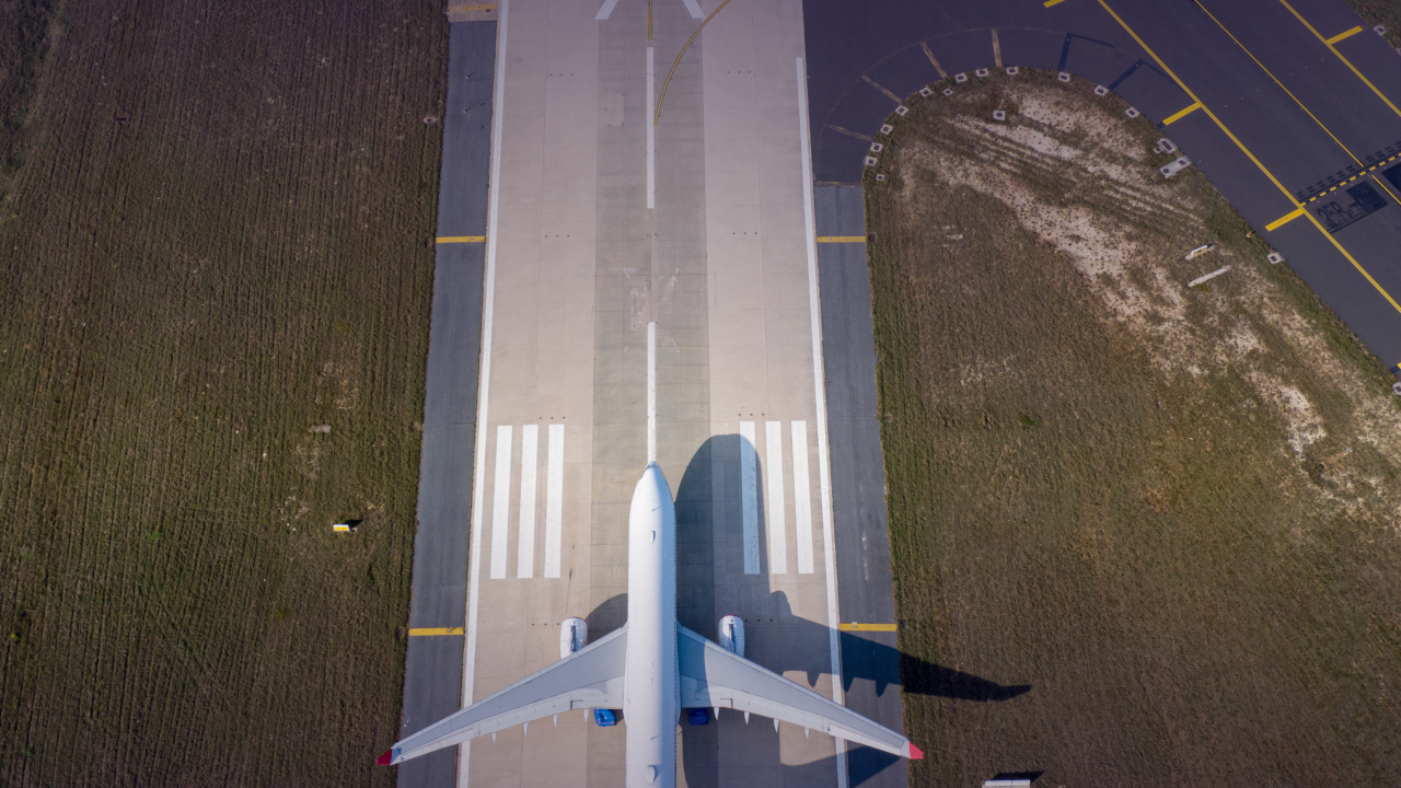 A commercial airplane sits on the runway at an airport waiting for takeoff.