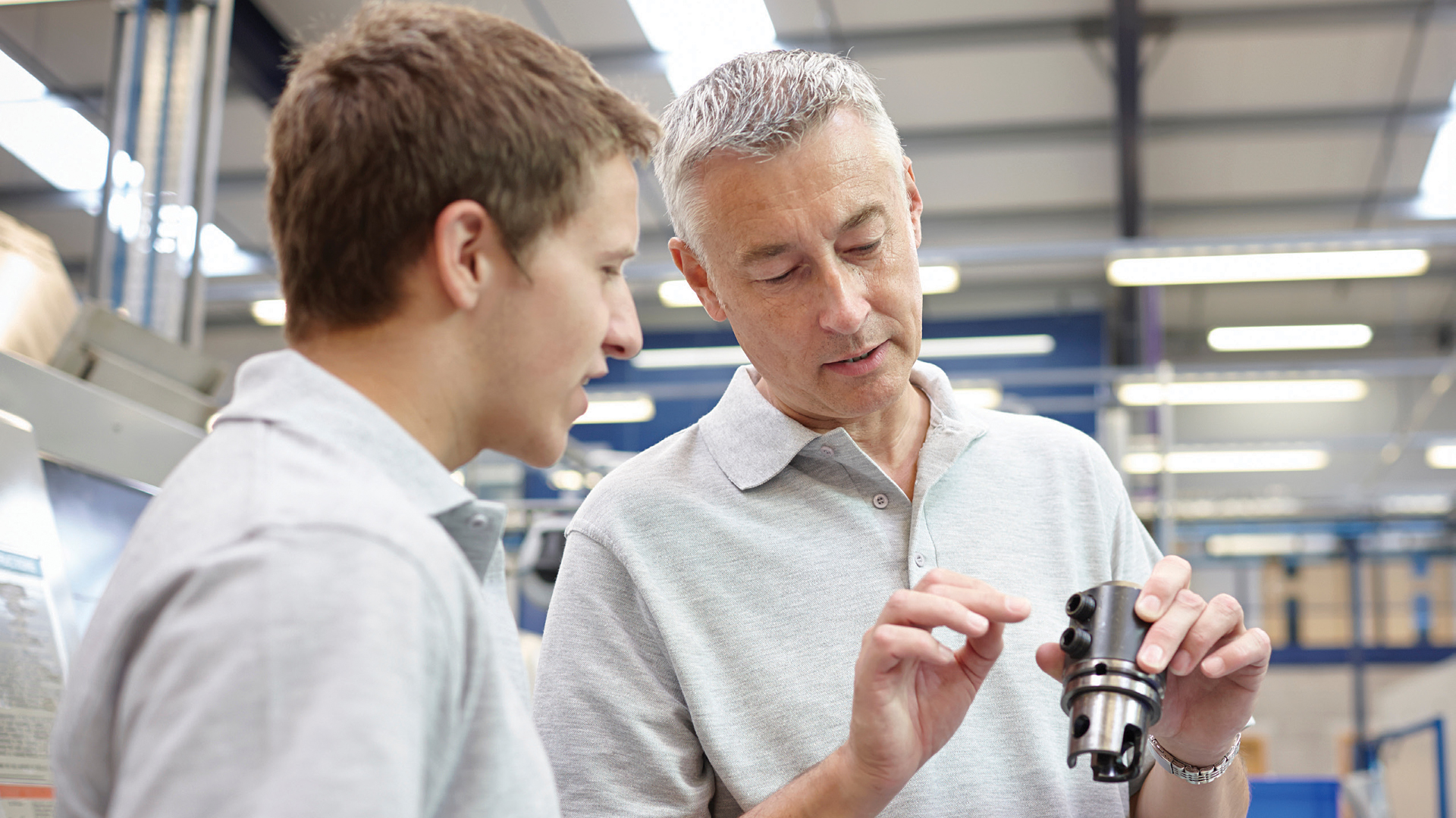 Two engineers inspect a machine component