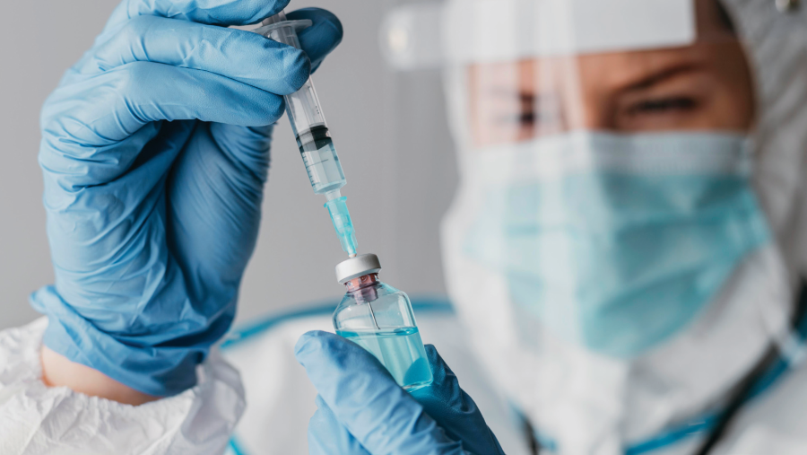 Image of doctor drawing a vaccine through a needle