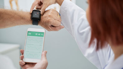 Doctor showing patient how to use smart medical device that connects watch to smart phone.