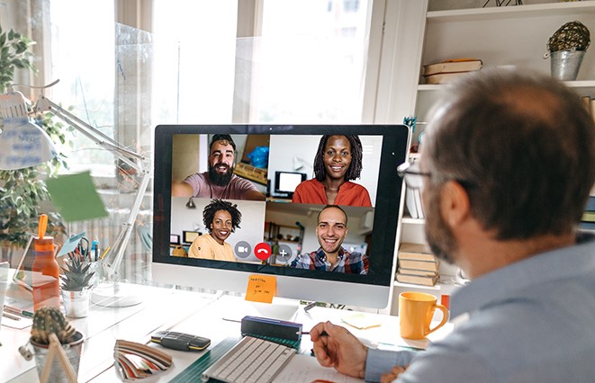 man meeting with remote software deployment team via video call