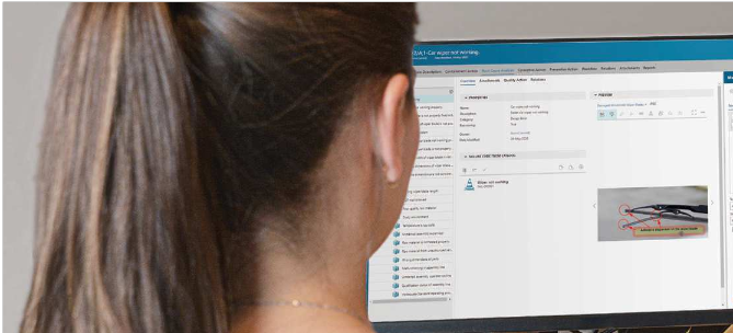 worker looking at computer screen showing Teamcenter Quality Management software