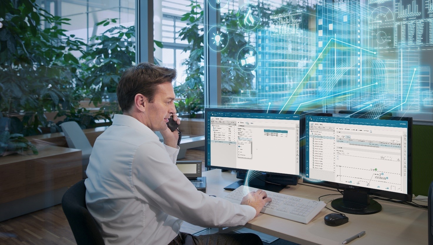 quality manager sitting at his computer reviewing using quality and spc software