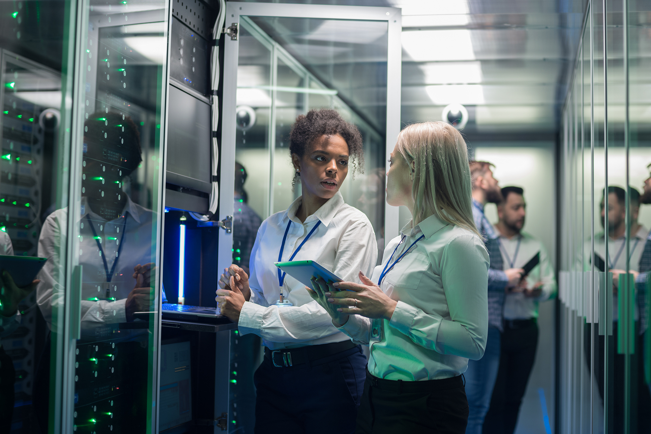 Two women in a server room discussing MES and ERP systems