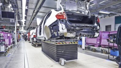Image of automotive factory showing cars moving along the final assembly line.