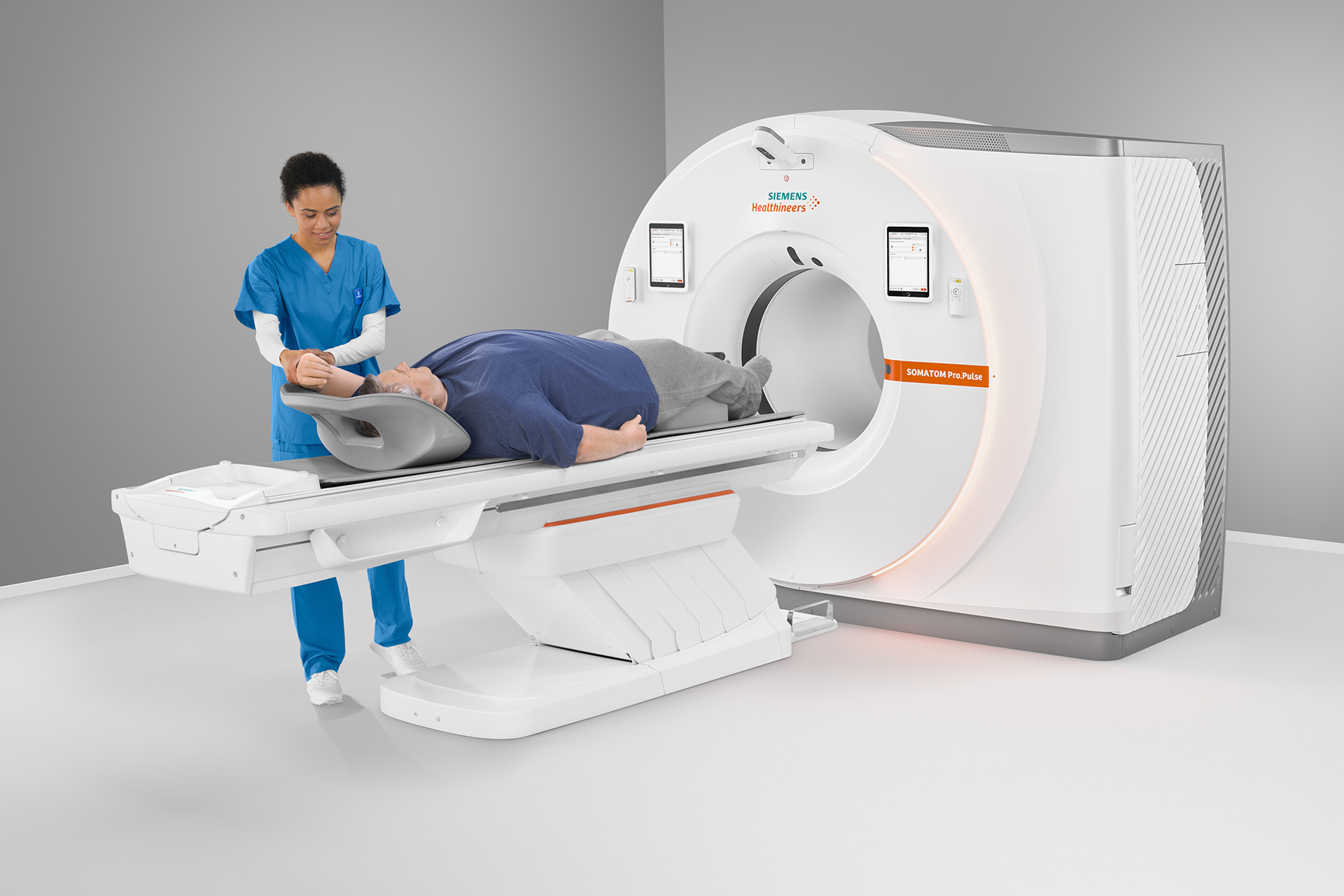 Healthcare professional operating an MRI machine with a patient lying down for a scan