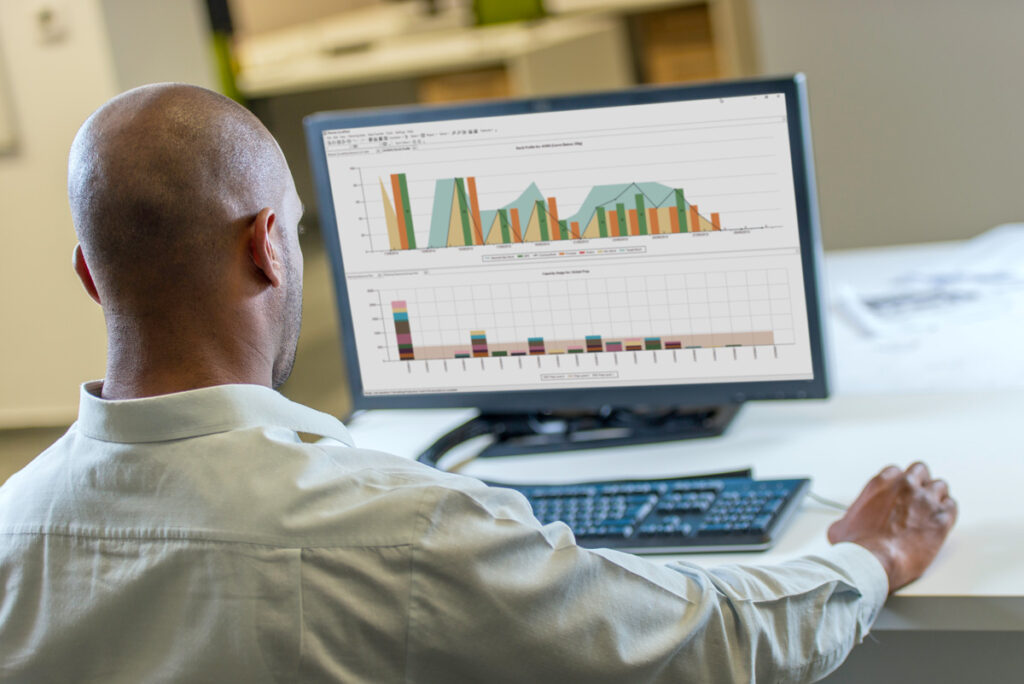 Guy sitting at a pc looking at Opcenter APS