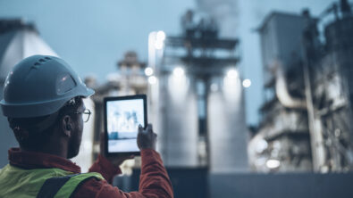 Engineer holding tablet with digital twin of power plant