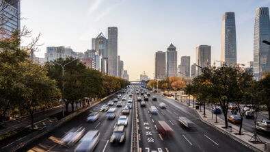 A busy highway filled with cars driving in both directions through a city.