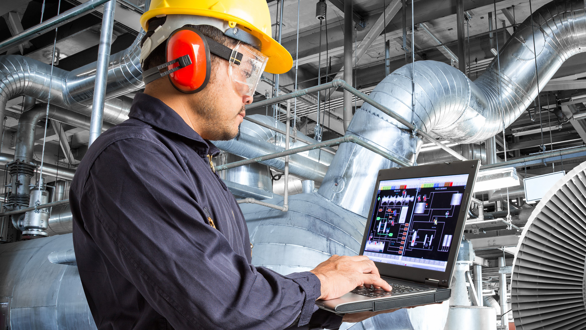 Engineer at manufacturing plant using software