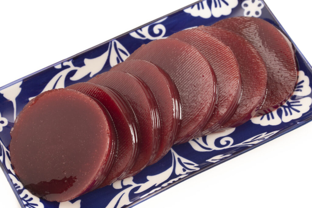 Sliced, canned cranberry sauce on a rectangular, blue and white ceramic plate